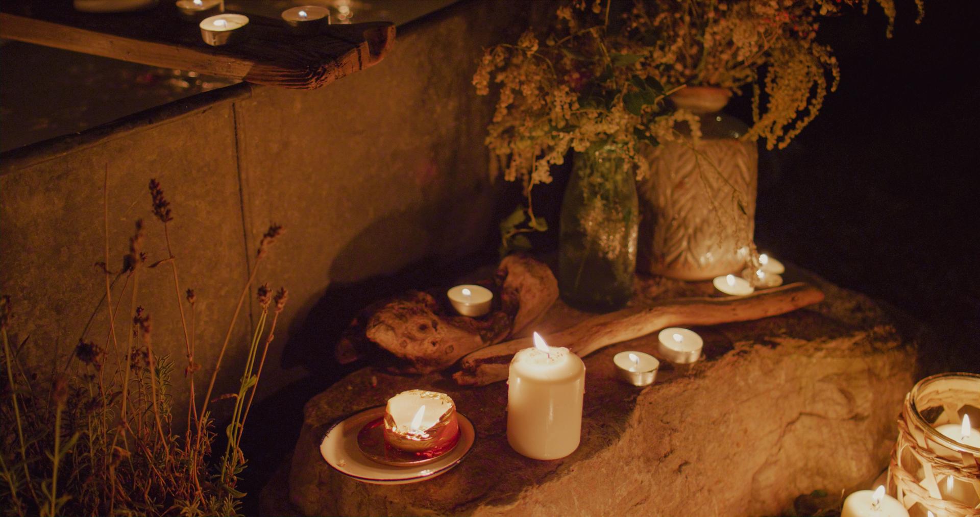 A zinc bathtub in the garden. Lots of candles around it.