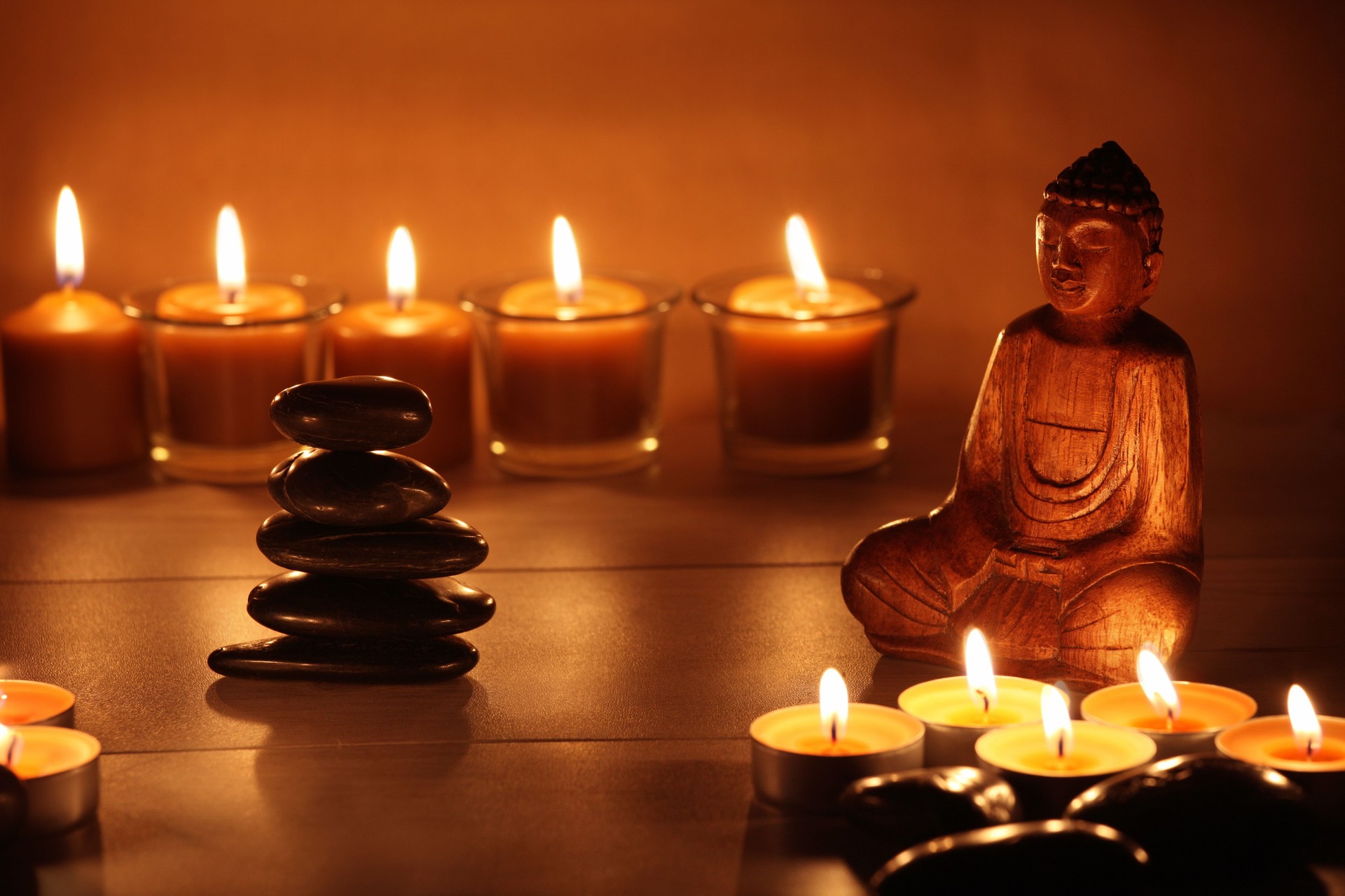 Zen stones balancing with candles and a Buddha figure