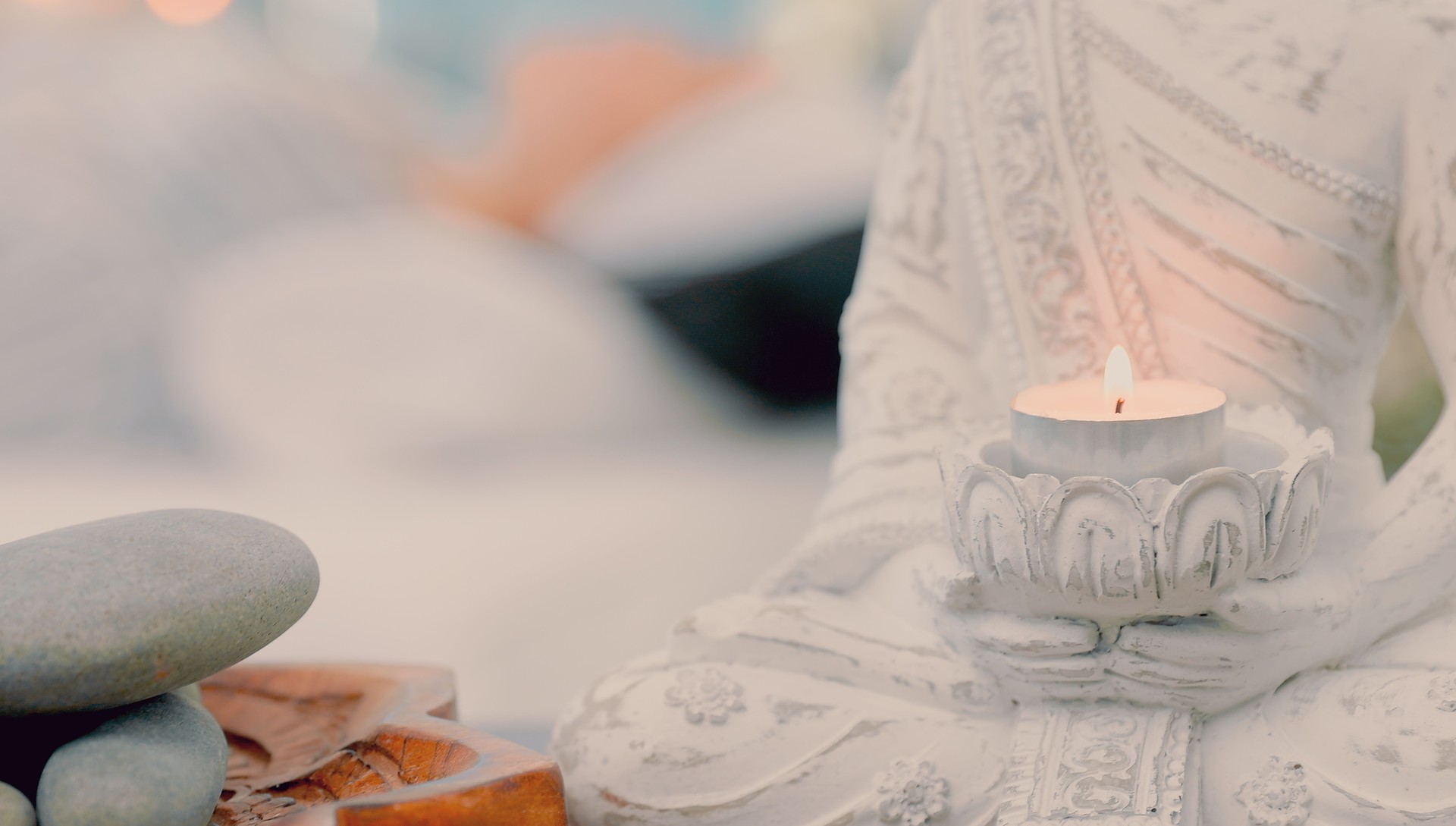 Shot of a buddha statue and candle holder at a spa during the day